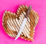 heart-shaped-bread-and-knife-on-pink-background-top-down-view-of-freshly-baked-and-sliced-heart-pictures_csp44068380